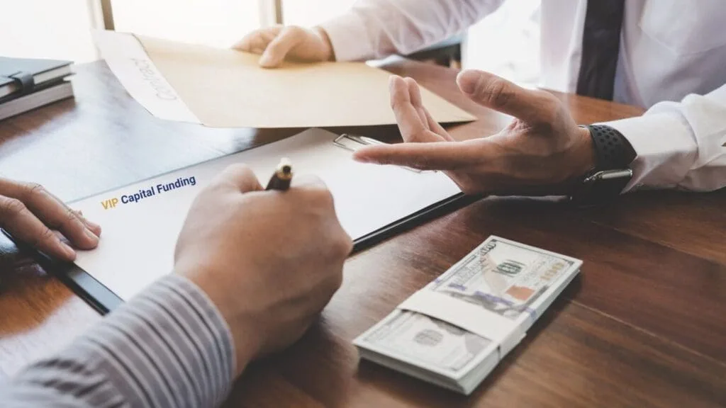 A person is signing papers and money