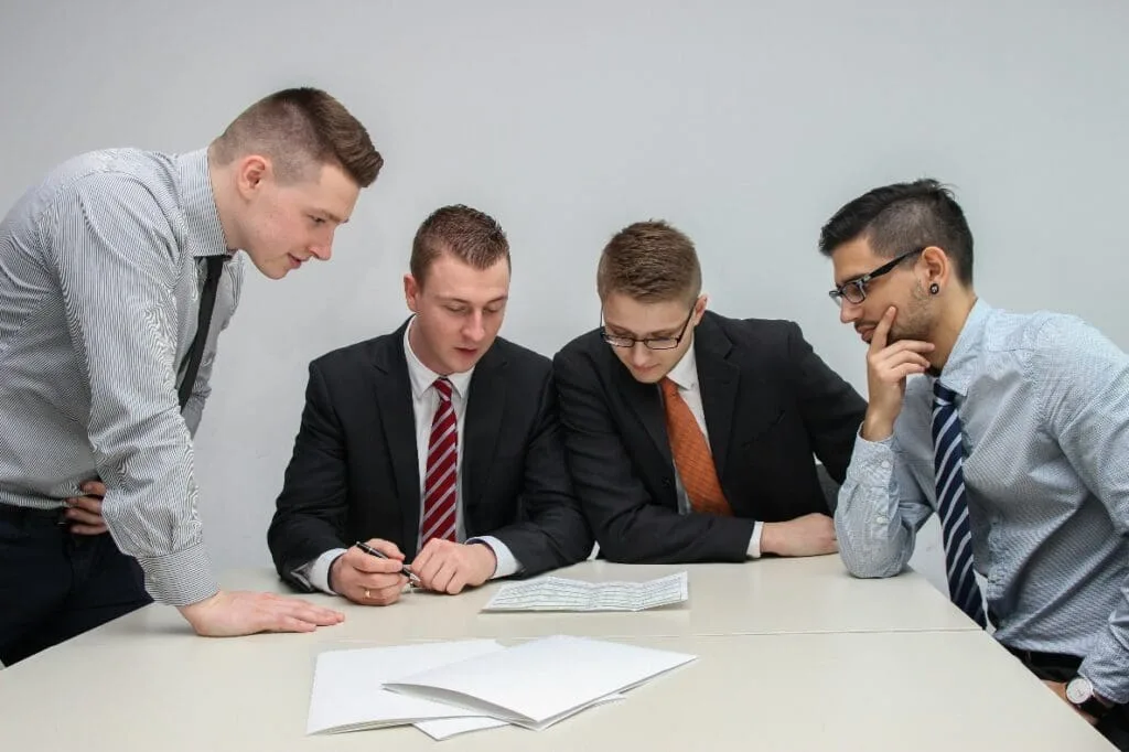 A group of men sitting around a table.