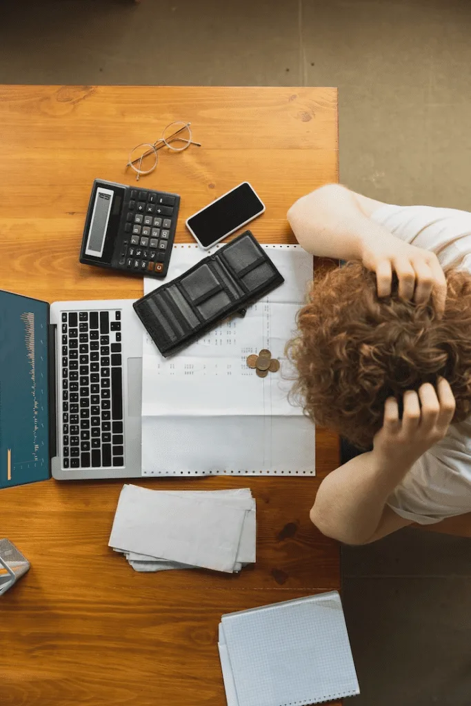 A person sitting at a desk with their head down.