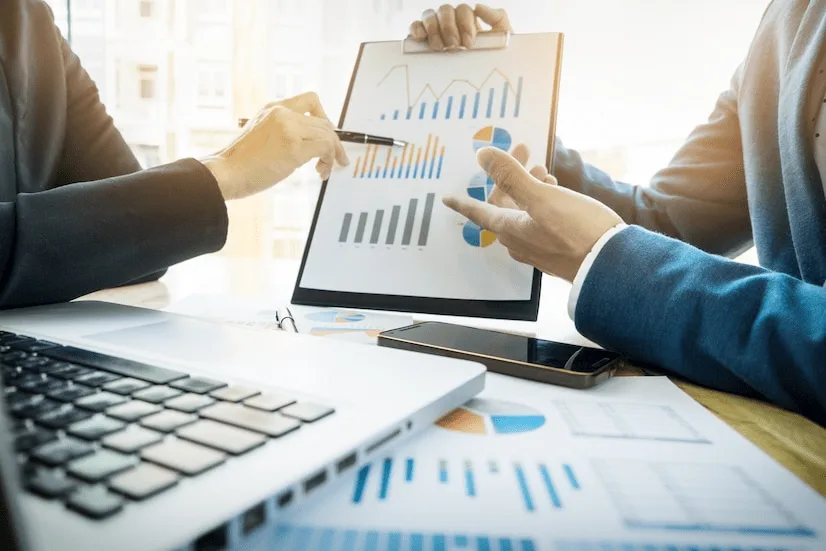 A group of people sitting at a table with papers.