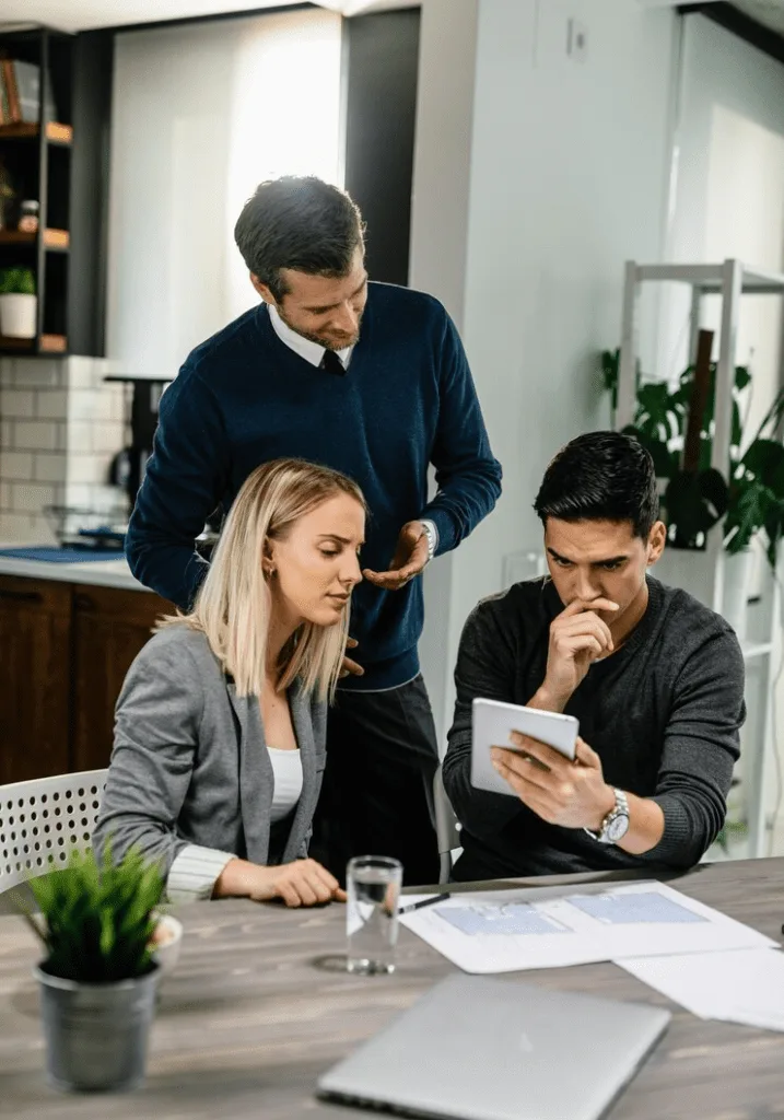 A group of people sitting at a table looking at papers.