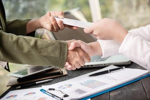 A small business owner shaking hands with a loan provide