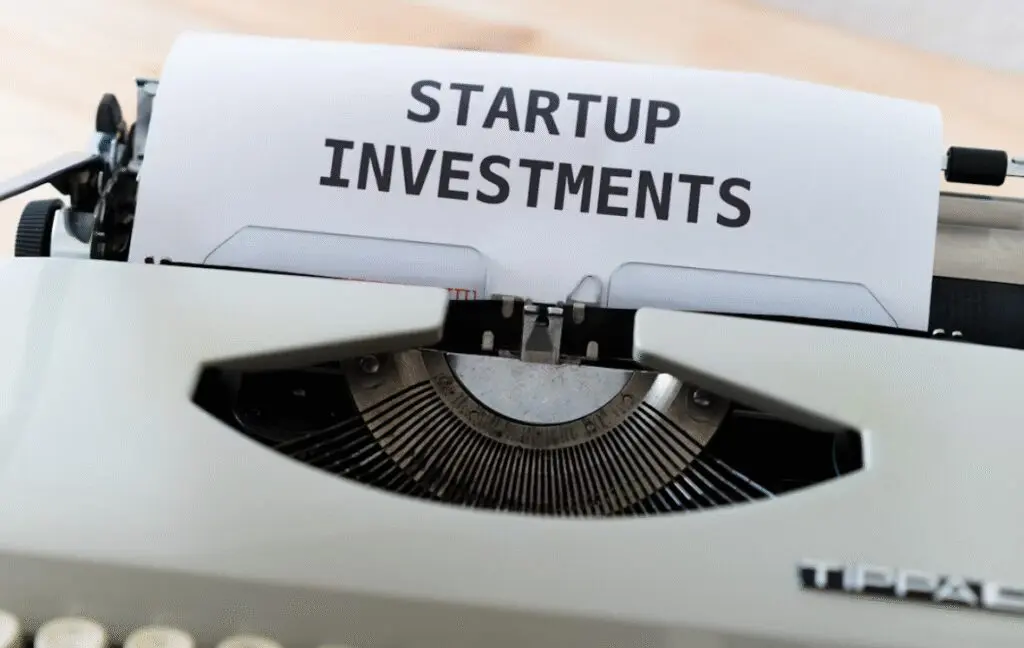 This picture shows a white type writer has typed ‘startup investments’.