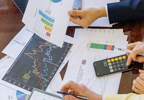 Papers and documents on a desk being reviewed for determining business loan needs.