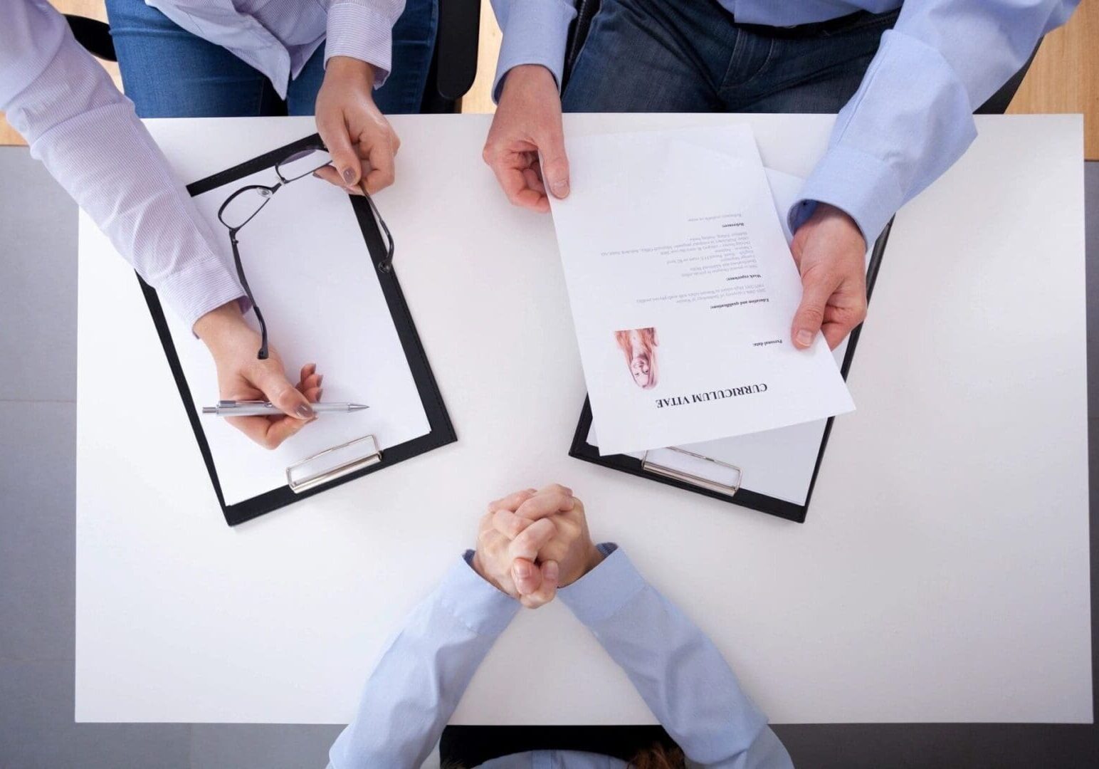 A group of people sitting at a table with papers.