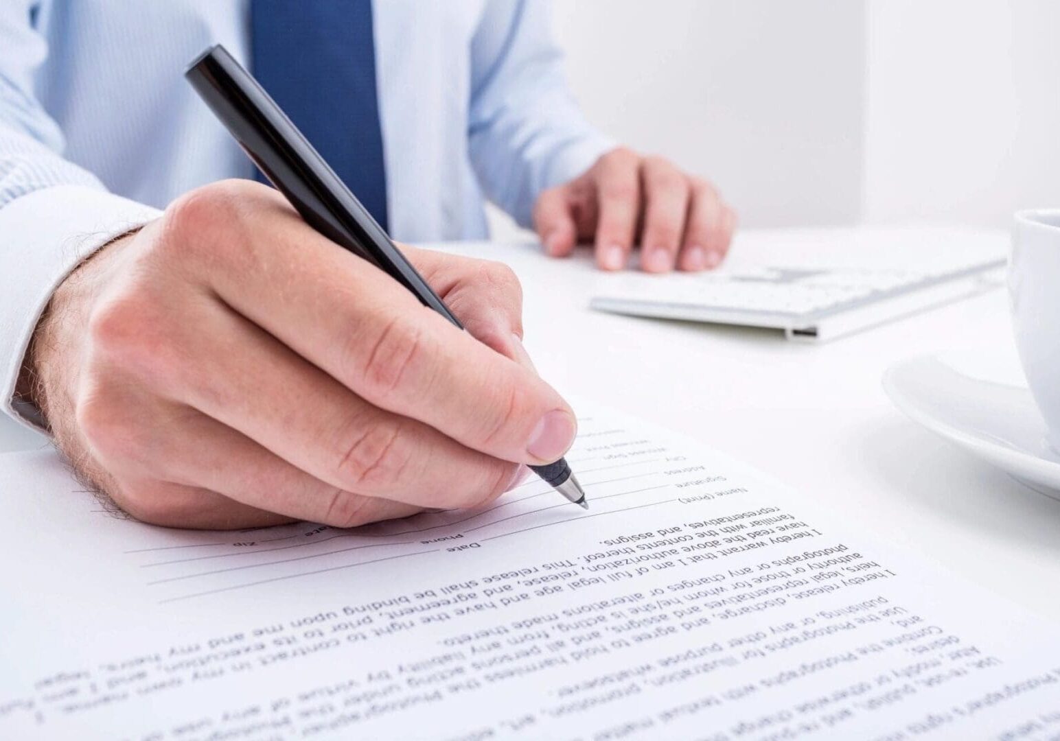 A person is writing on paper with a pen.